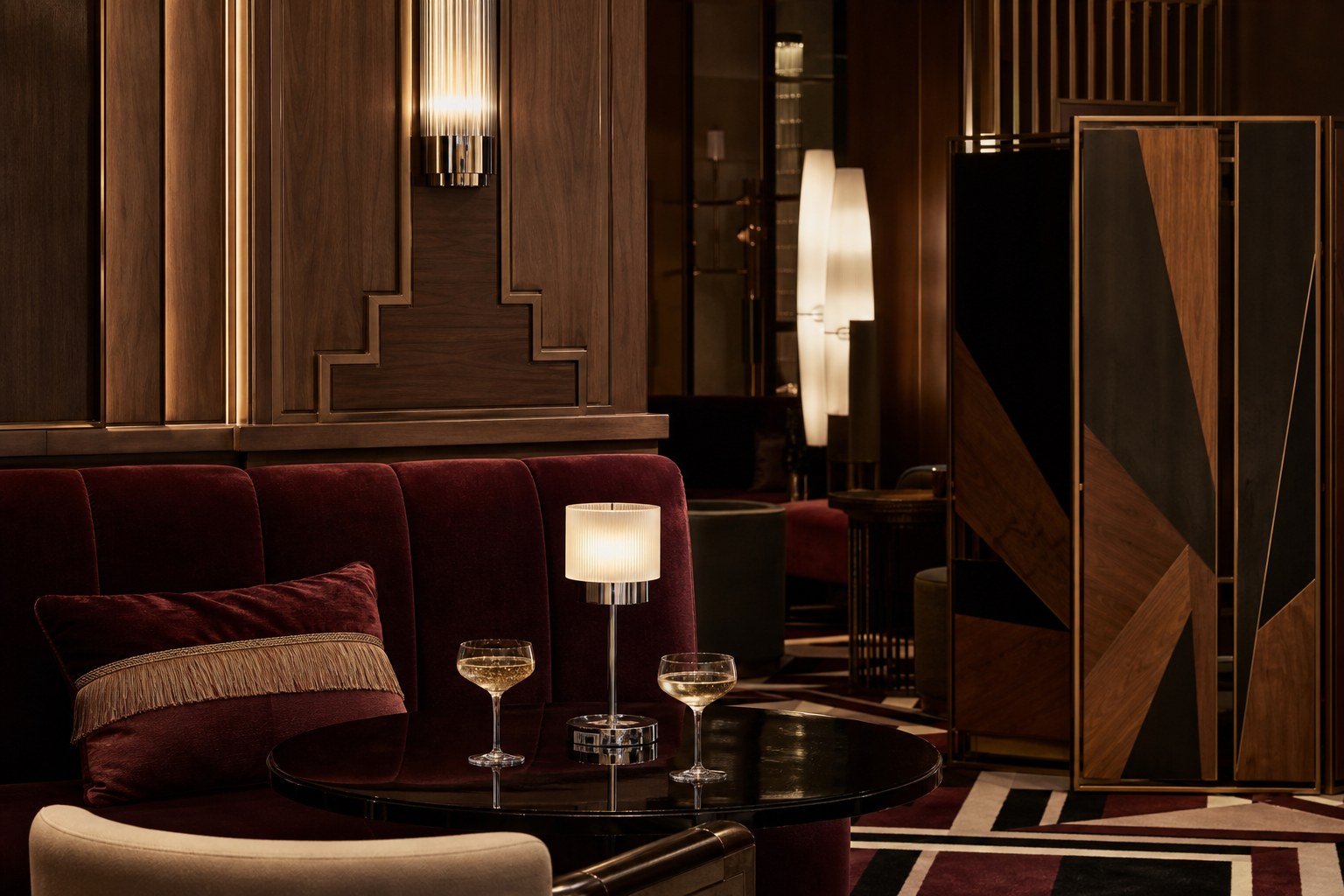 Contemporary Art Deco lounge with oxblood velvet, walnut panels, frosted glass and black lacquer