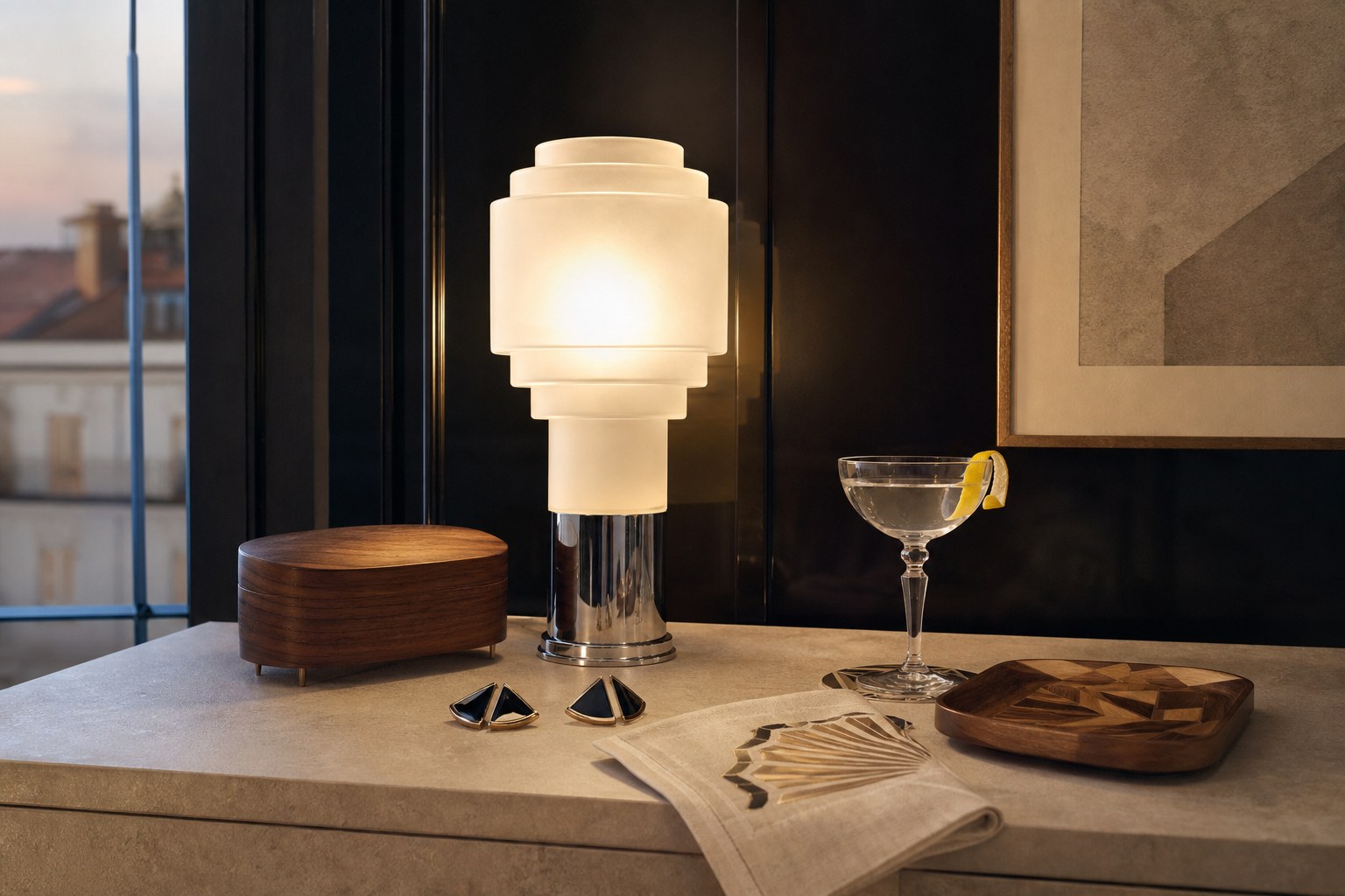 Stepped frosted-glass lamp, walnut box, geometric jewellery and coupe glass on a stone console