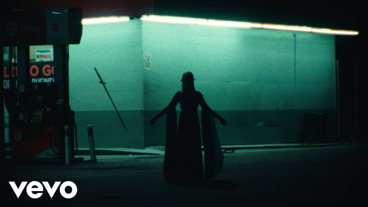 Silhouetted sword-carrying figure outside a fluorescent convenience store in the Lost Boys music video