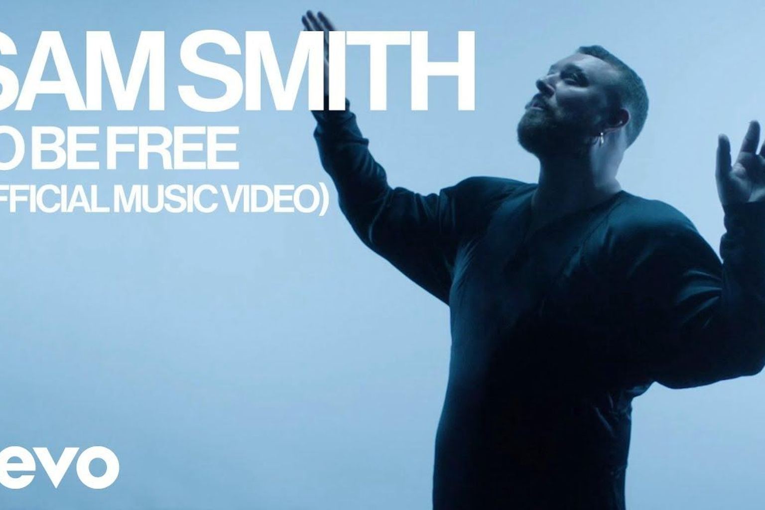 Official image from Sam Smith's To Be Free video with the singer reaching upward in blue light