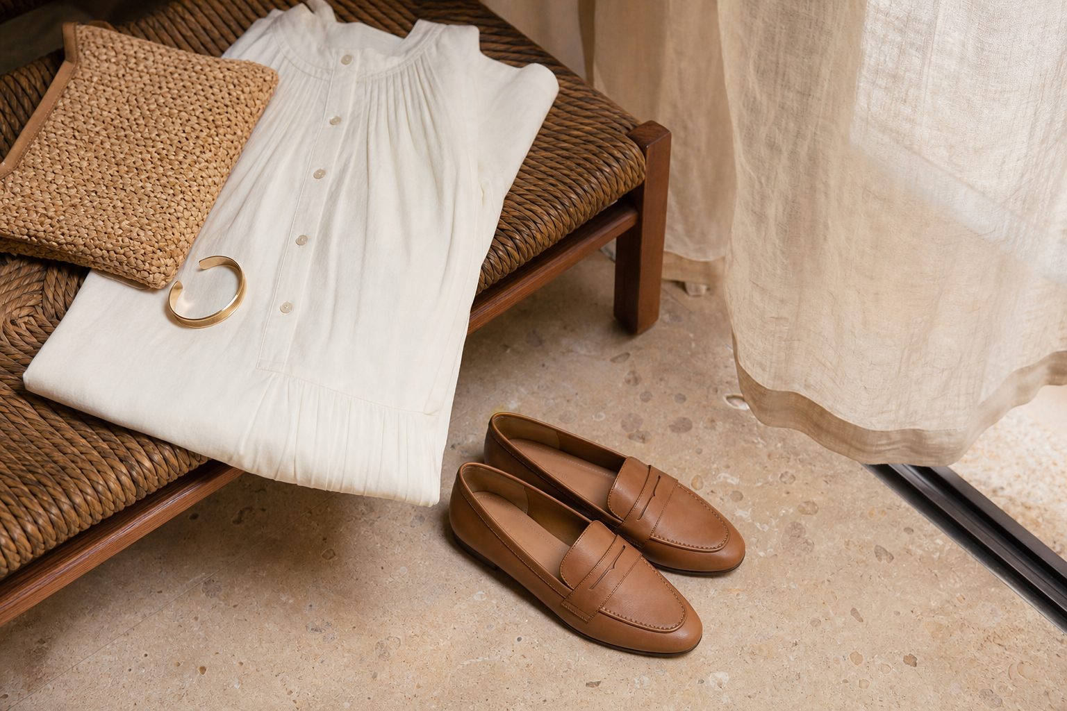 Summer dress, tan loafers, raffia clutch and gold bangle on woven bench