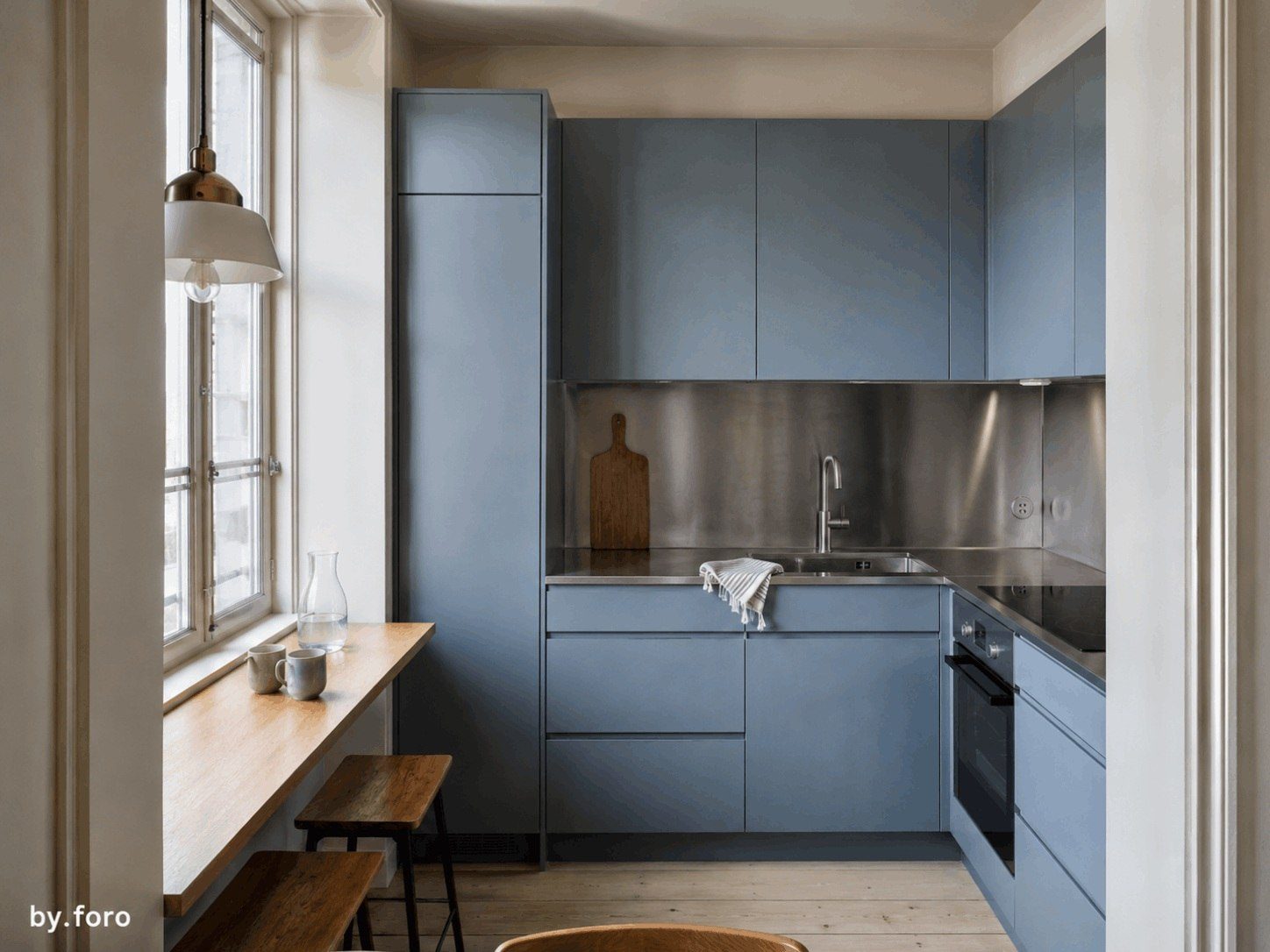 Compact pale blue and stainless steel kitchen in a Copenhagen apartment