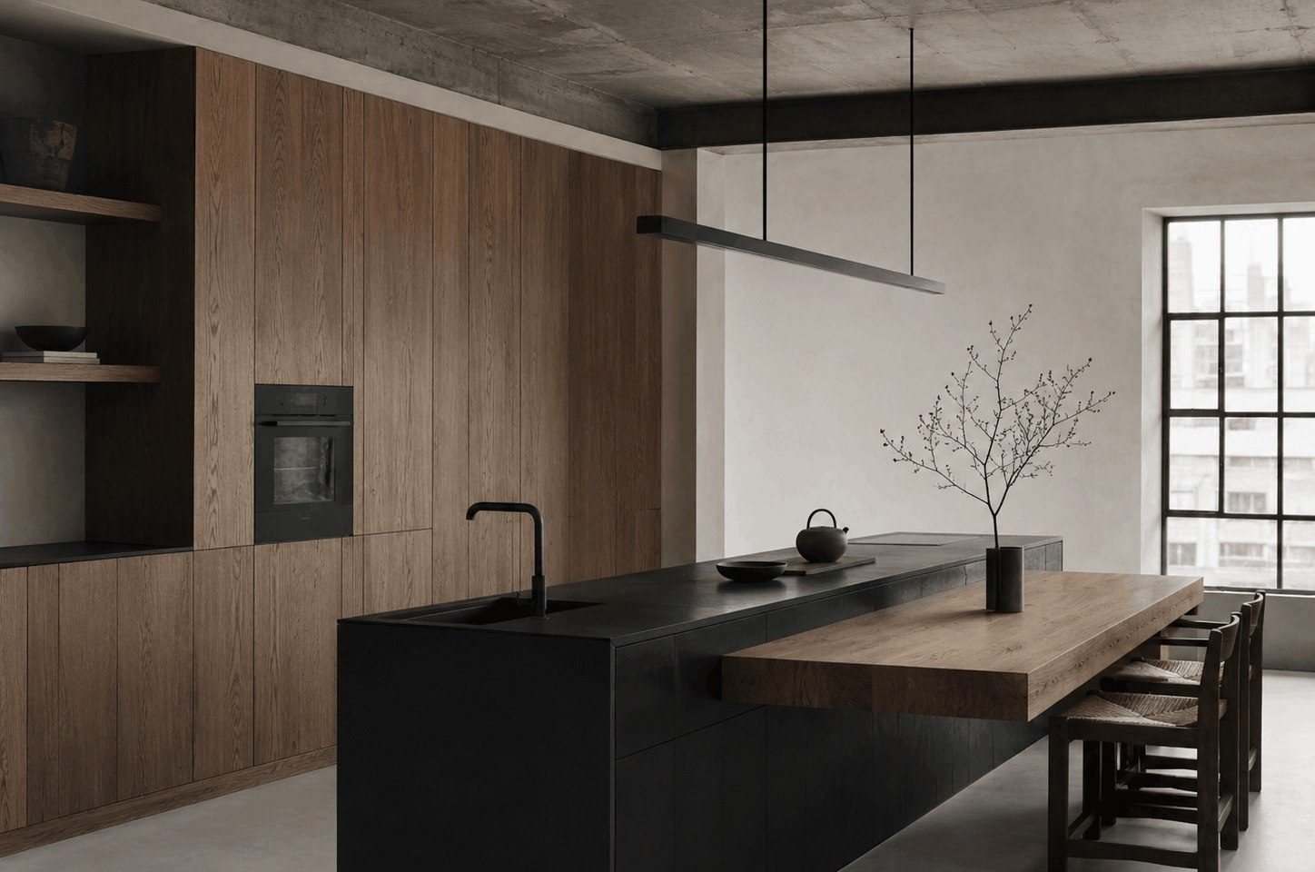 Minimal black, oak and soft white kitchen with hidden appliances and slim linear pendant light