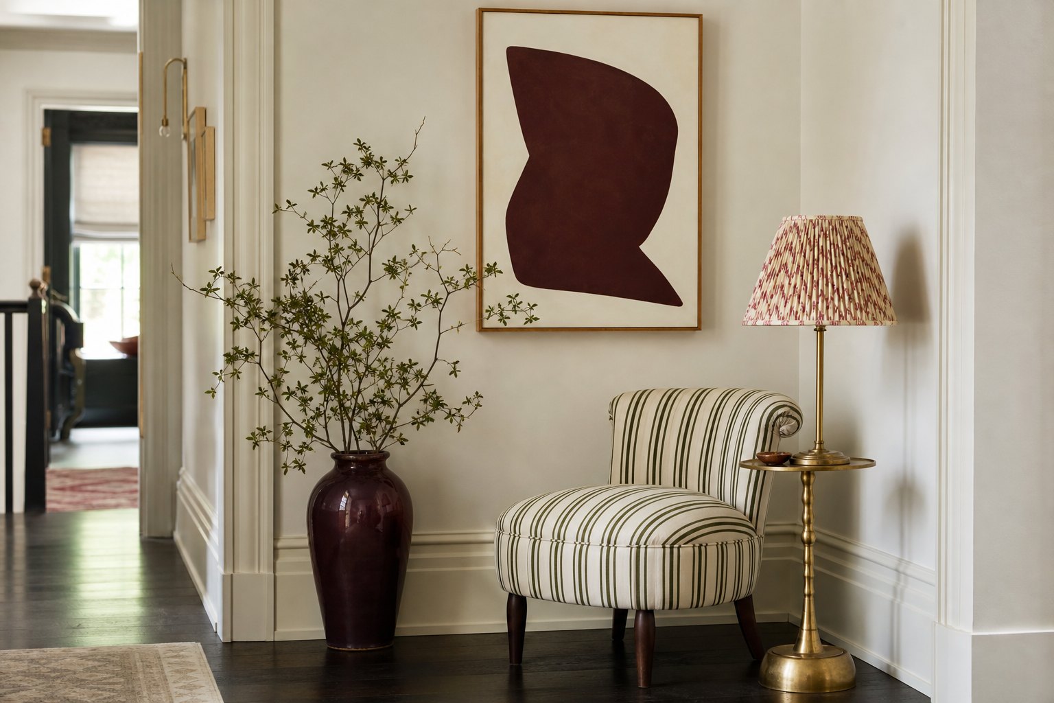 Whimsical hallway corner with striped chair, abstract burgundy art, ceramic vase and patterned lampshade