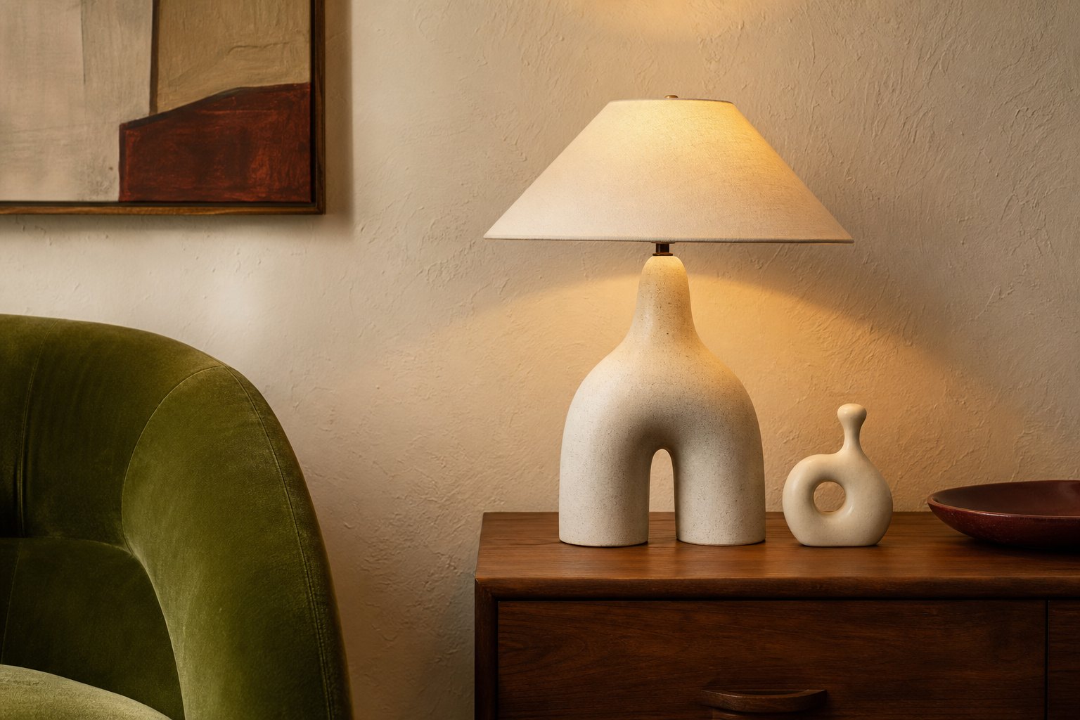 Whimsical interior detail with sculptural ceramic lamp, moss velvet chair and walnut side table